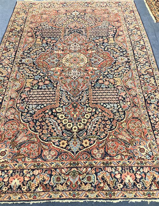A Central Persian carpet with floral figured red ground central medallion on an all-over floral indigo field, 300 x 200cm